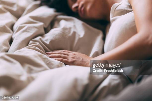 peaceful woman sleeping comfortably in cozy bed at home - sleeping stock pictures, royalty-free photos & images