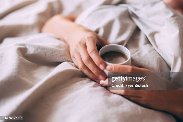 matinée relaxante au lit avec une tasse de café chaud - douceur photos et images de collection