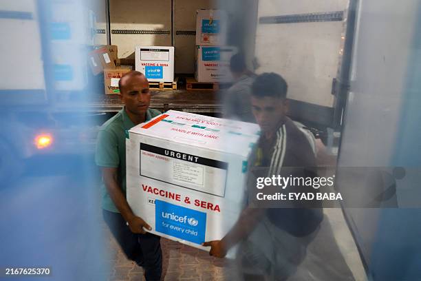 Workers unload a shipment of polio vaccines provided with support from UNICEF to the Gaza Strip through the Karm Abu Salem crossing, also known as...