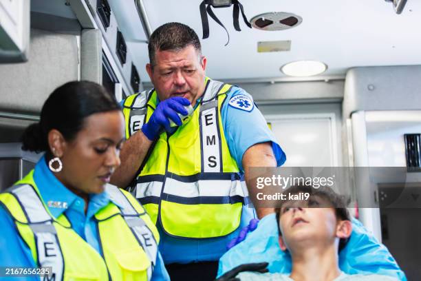 paramedics inside ambulance with teenage boy on stretcher - pessoal de ambulância imagens e fotografias de stock