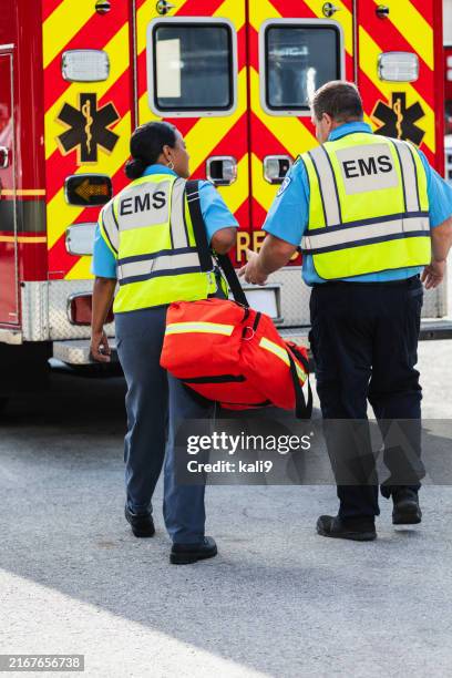 des ambulanciers marchent vers une ambulance de secours - ambulance rear view photos et images de collection