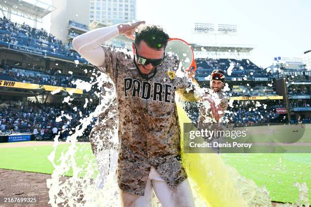 Jackson Merrill of the San Diego Padres is doused with a cooler after hitting a walk-off solo home run in the ninth inning against the New York Mets...