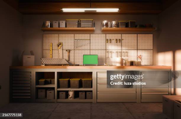 inside of a garage in the afternoon sun, laptop with green screen on the workbench - workbench stock pictures, royalty-free photos & images