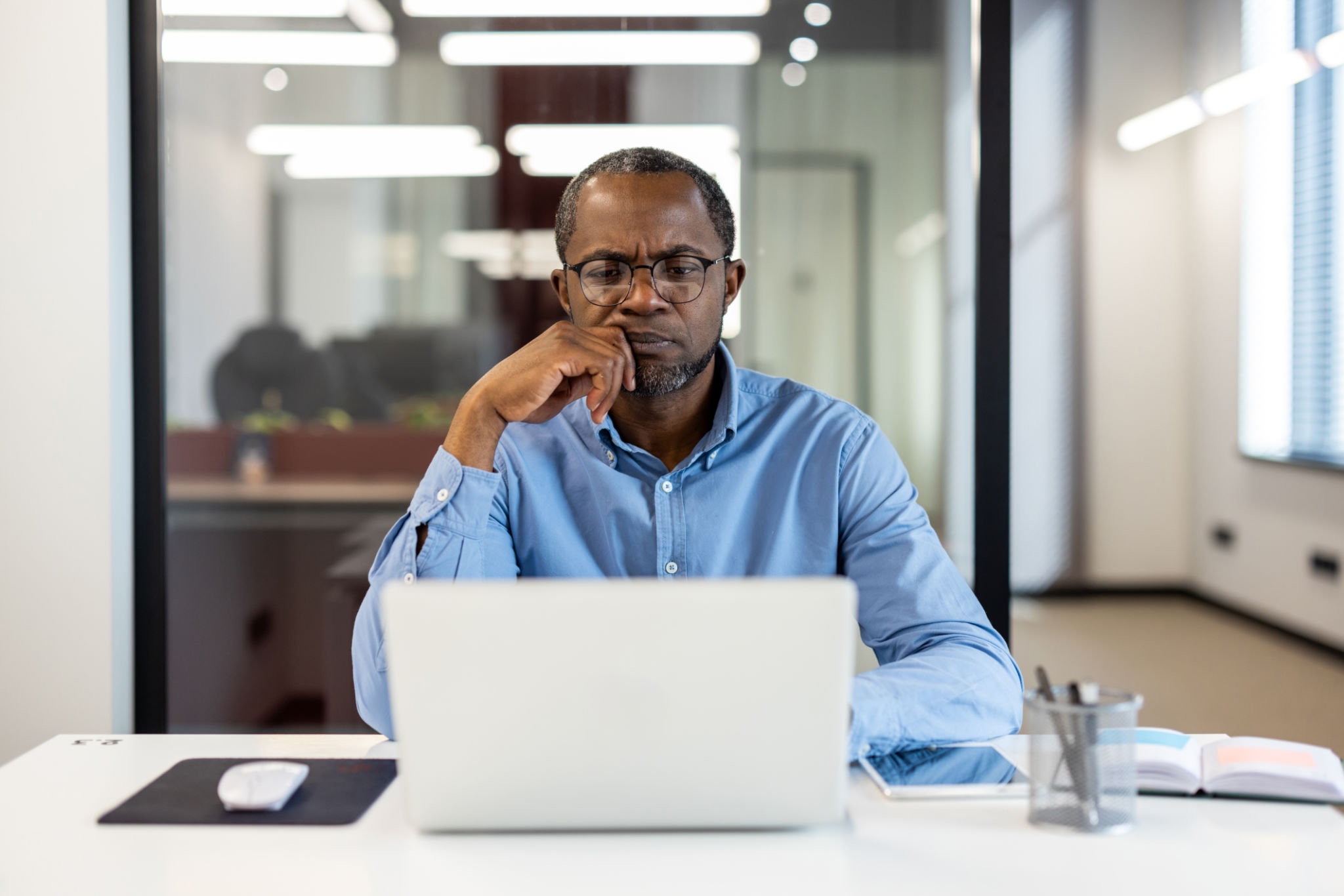 Focused businessman working on laptop in modern office Focused businessman working on laptop in modern office