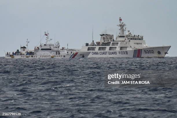 China Coast Guard ship is seen past the Philippine Coast Guard ship BRP Cape Engaño , as photographed from the BRP Cabra during a supply mission to...