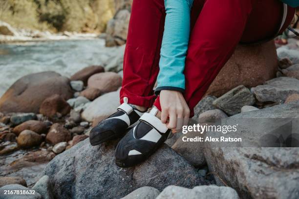close up shot of rock climber puting on climbing shoes - nylonband mit klettverschluss stock-fotos und bilder