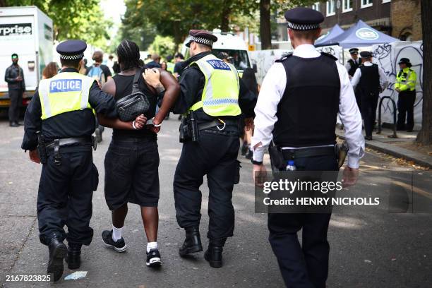 Police officers make an arrest at the Notting Hill Carnival in west London on August 26, 2024.