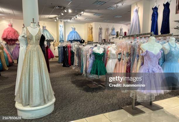 elegantes vestidos de noche de fantasía que cuelgan de percheros en una boutique de vestidos formales de clase alta - vestido-de-noche fotografías e imágenes de stock