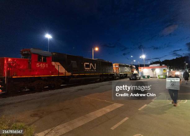 Teamsters union member walks the picket line at the entrance of CN Rail Lynn Creek Yard on August 21, 2024 in North Vancouver, British Columbia,...