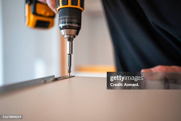 caucasian man installing kitchen cabinets - screwdriver stock pictures, royalty-free photos & images
