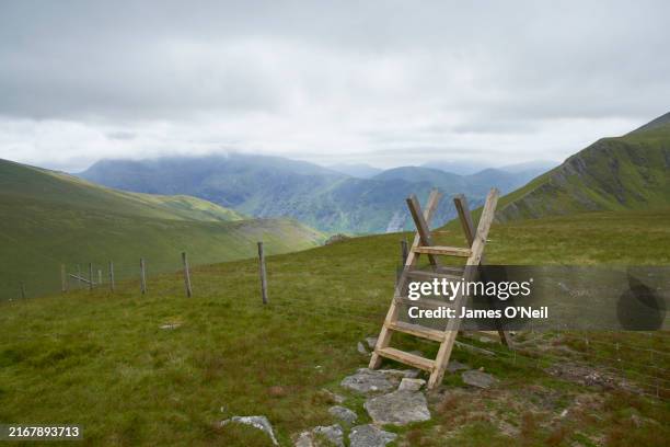mountain terrain with a stile going over a fence. - stye stock pictures, royalty-free photos & images
