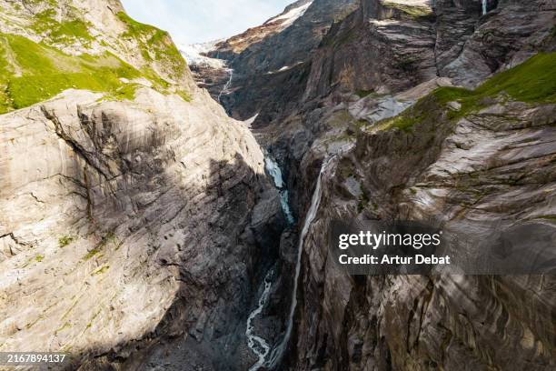 aerial close view flying in the remote canyon with glacier waterfall in switzerland - vertigo stock pictures, royalty-free photos & images