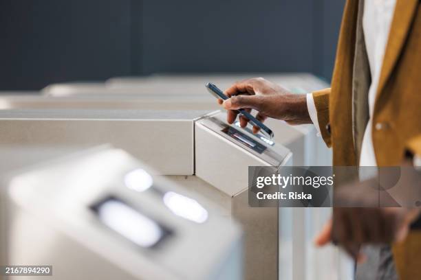 nahaufnahme eines mannes, der kontaktlos am eingang des u-bahn-drehkreuzes bezahlt - kontaktlos bezahlen stock-fotos und bilder