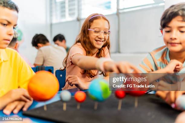 child students talking and doing a model of solar system during class at school - science fair stock pictures, royalty-free photos & images