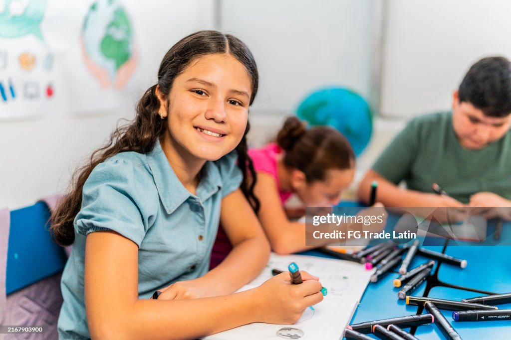 Portrait of child girl drawing during class at school