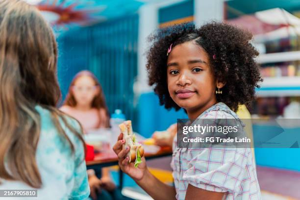 portrait of child girl eating on snack time at school - endast flickor bildbanksfoton och bilder