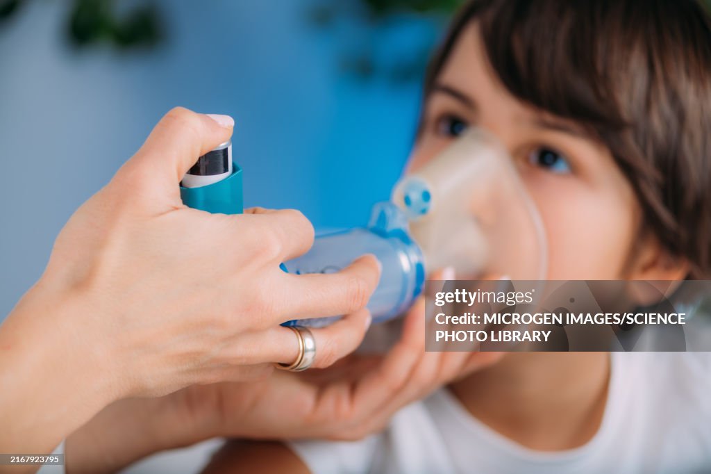 Pulmonologist helping boy with aero chamber