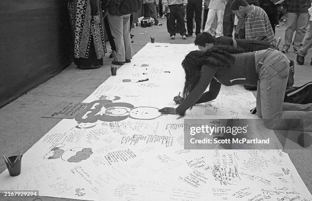 View of people as they kneel and write on a large canvas to commemorate the 5th anniversary of the September 11 terrorist attacks, on Church Street...