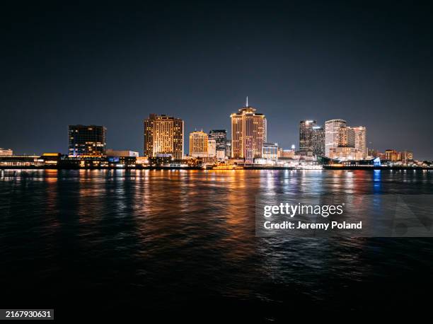 long exposure of lights reflecting from new orleans, louisiana skyline from the mississippi river at night - bridge architecture up close night stock pictures, royalty-free photos & images