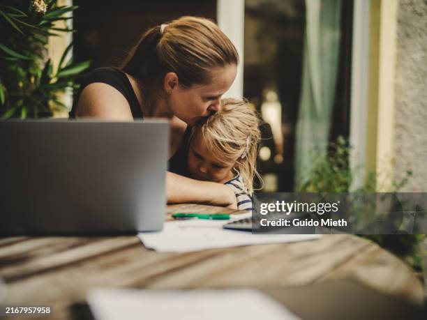 woman embracing her daughter while doing homeoffice. - nuova normalità concetto foto e immagini stock