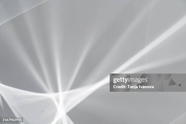 texture of the surreal effect of refraction of white light on grey wall. blurred background with abstract shadows and lights. - lichtbrechung stock-fotos und bilder