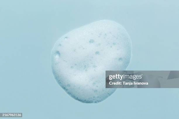 white smear of foam on blue background. - shampoo stock pictures, royalty-free photos & images