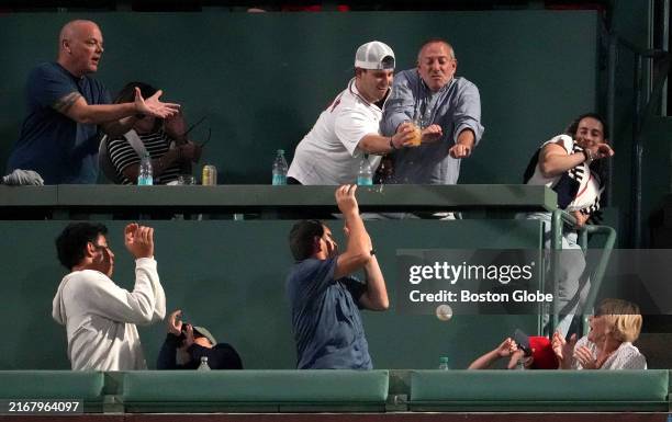 Boston, MA Boston Red Sox fans vie for a home run ball atop the Green Monster in the seventh inning.