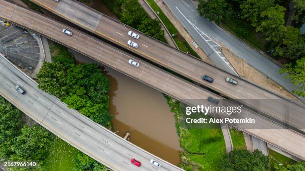 urban river crossing. busy highways span muddy buffalo bayou waters in houston, tx - houston park stock pictures, royalty-free photos & images