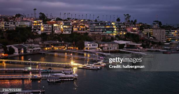 luxuriöse häuser und bootsanlegestellen in corona del mar bei twilight in newport beach, ca - newport beach stock-fotos und bilder