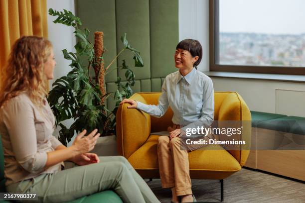 blonde female having a job interview with a manager - couch interview stock pictures, royalty-free photos & images