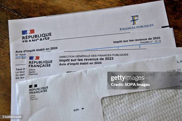 Income tax notice documents for the year 2023 seen displayed on a table in France.