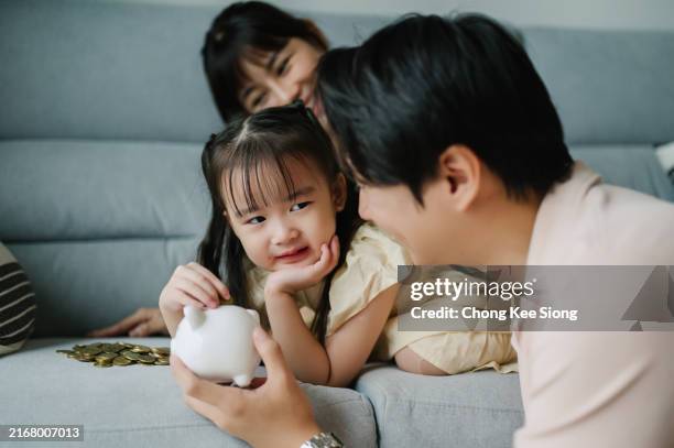 asian young chinese family with piggy bank. - financial literacy stock pictures, royalty-free photos & images