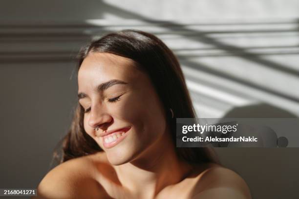 close-up portrait of a beautiful young woman - sunlight stock pictures, royalty-free photos & images