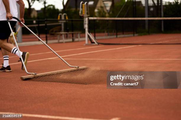 tennis player cleaning clay court before tennis practice - sweeping stock pictures, royalty-free photos & images