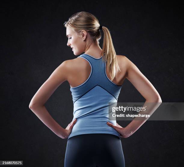 donna, schiena e fitness con fiducia in studio per la salute e il benessere su uno sfondo nero. persona femminile attiva o giovane modello con le mani sull'anca nella moda per lo sport, palestra di allenamento o allenamento - dorso umano foto e immagini stock