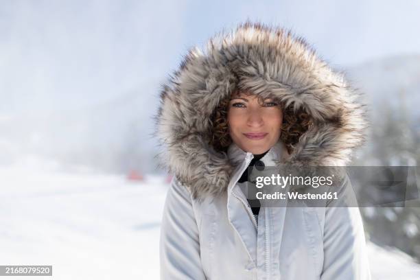 smiling woman in parka coat with fur hood - casaco de inverno imagens e fotografias de stock