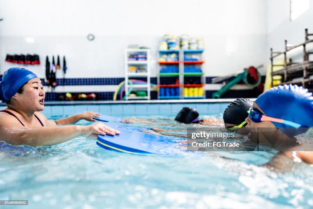 Instructing Class Instructor Talking With Children During Exercise Class At Swimming Pool ...