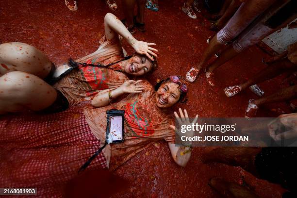 Revellers take part in the "Tomatina" annual food battle in the Spanish eastern town of Bunol, on August 28, 2024. Thousands of people gather in...