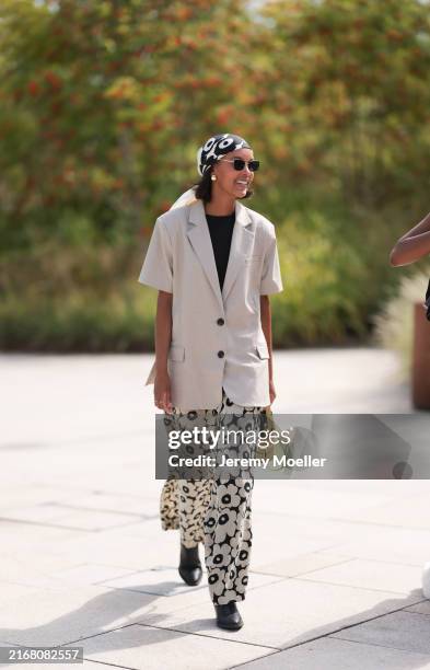 Jasmin Kuusiniemi is seen wearing a black and white floral patterned Bandana in her hair from Marimekko, rectangular sunglasses with silver metal...