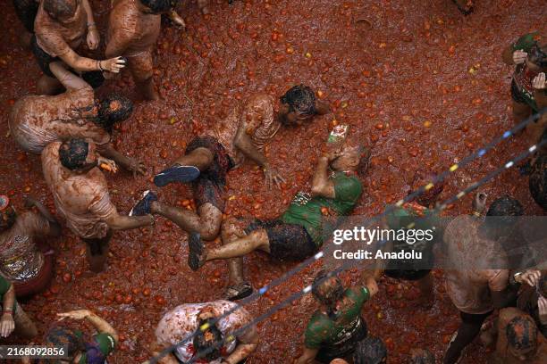 People covered in tomato pulp take part in the 77th 'Tomatina' Festival in the eastern town of Bunol, Spain on August 28, 2024. Threw a total of 120...