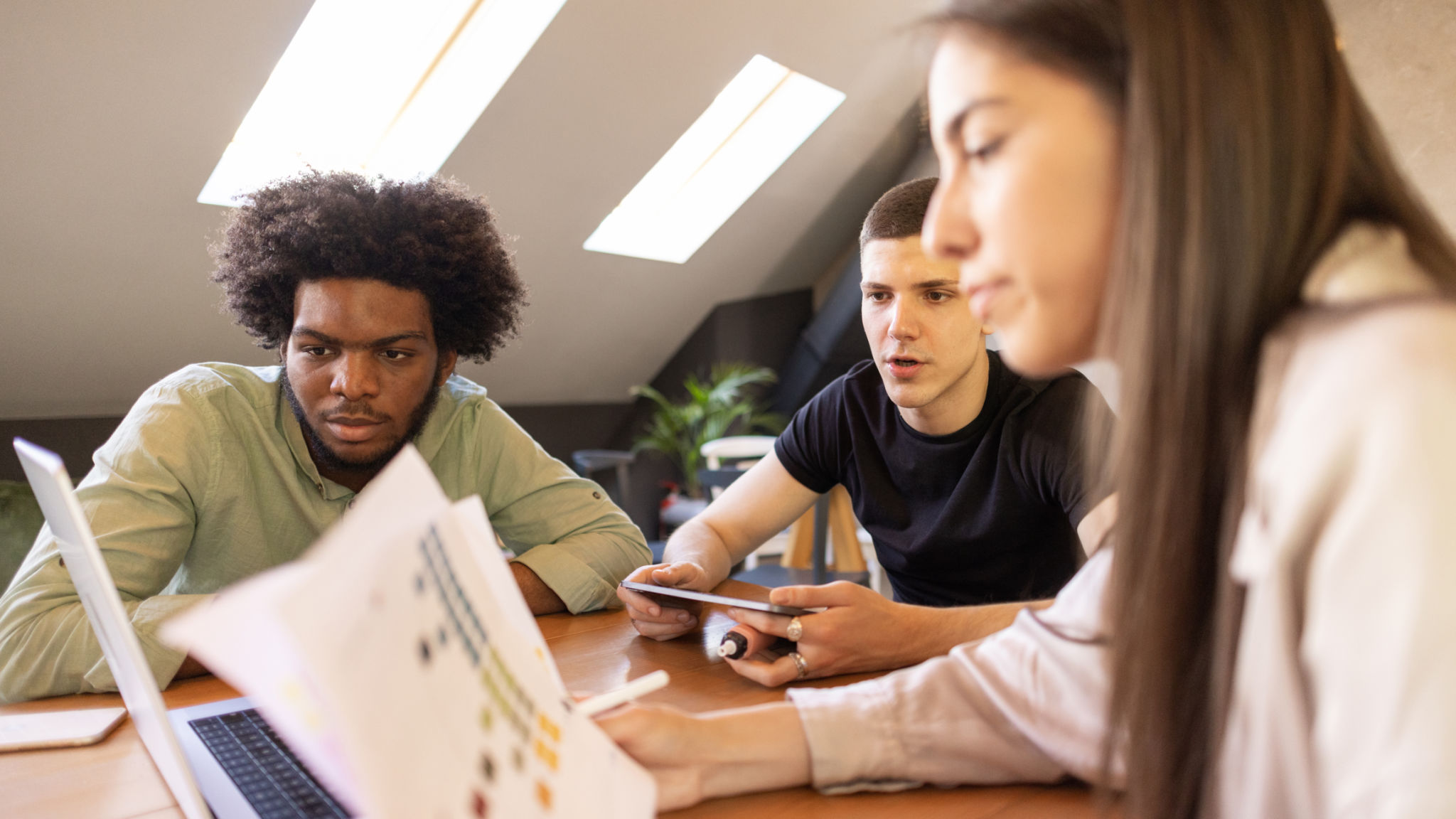 Multiracial group of young people, at the coffee shop, brainstorming new ways of investments Multiracial group of young people, at the coffee shop, brainstorming new ways of investments