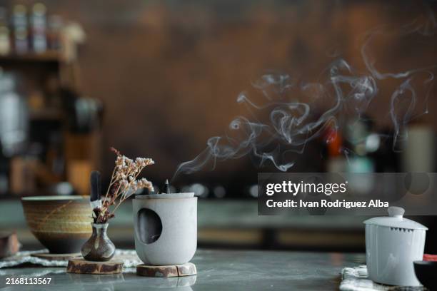 bâton d’encens libérant de la fumée pendant la préparation de la cérémonie du thé - encens photos et images de collection