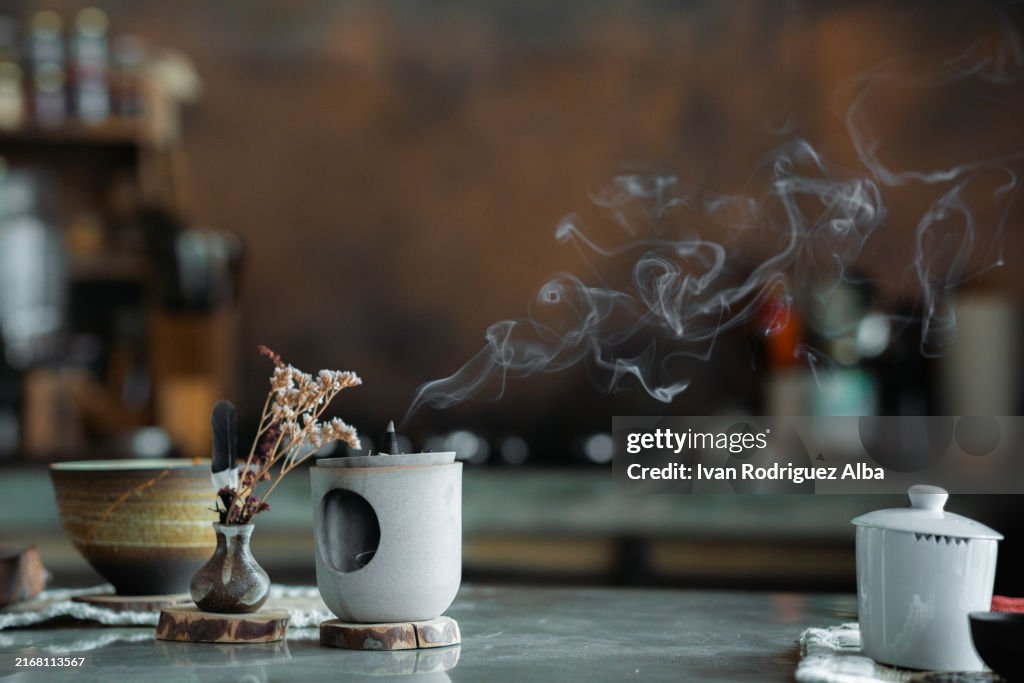 Incense stick releasing smoke during tea ceremony preparation