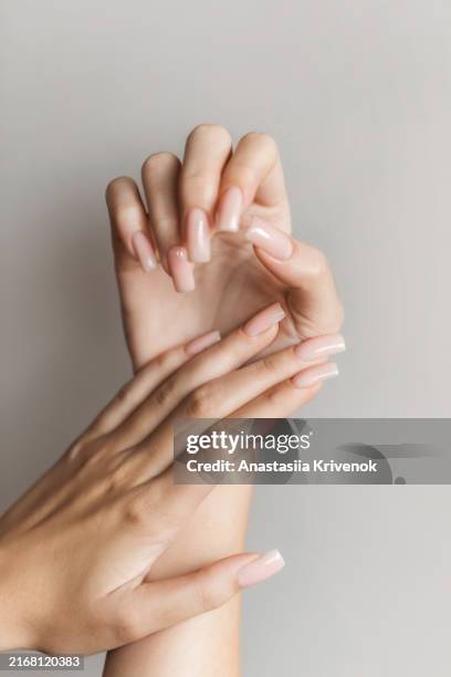 female hand with long nail polish manicure in beige glossy color. - long fingernails imagens e fotografias de stock