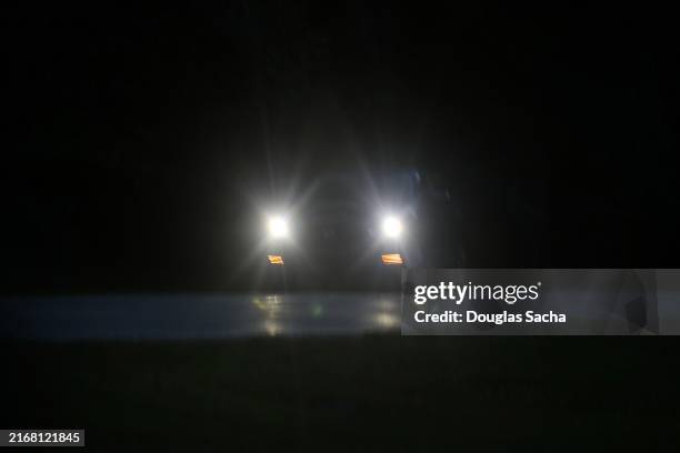 vehicle headlights on a dark rural road - headlight stock pictures, royalty-free photos & images