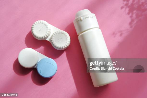 contact lenses with saline solution on pink background - contact lens stock pictures, royalty-free photos & images