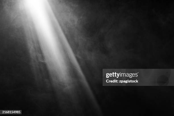 white and gray smoke against black background with light beams stock - sunbeam stock pictures, royalty-free photos & images