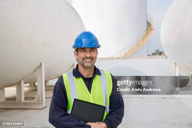engineer in front of storage tanks - casco de trabajo fotografías e imágenes de stock
