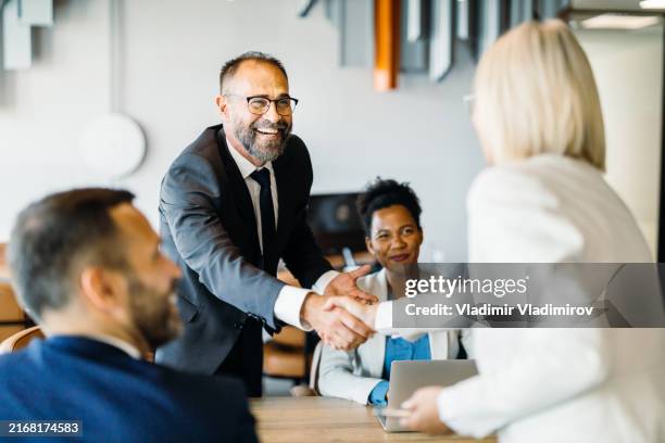 colleagues seal deal with a handshake - confiança imagens e fotografias de stock