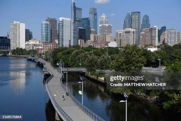 People walk on the Schuylkill River trail in Philadelphia on August 28 during a heatwave that has swept across the Midwest and parts of the East...